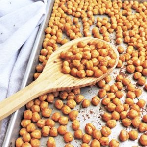 Simple Crunchy Roasted Garlic Chickpeas on a baking sheet with a wooden spoon