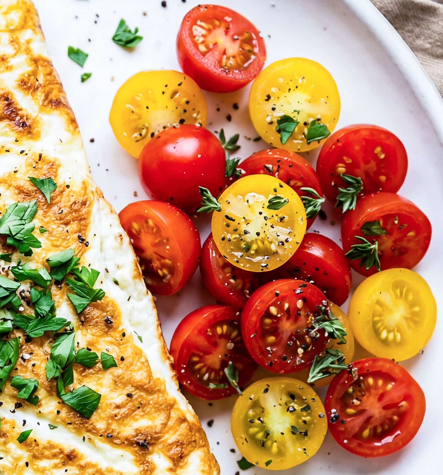 Veggie stuffed egg white omelet with spinach, peppers, mushrooms, and tomatoes on a white plate
beautifuleatsandthings.com