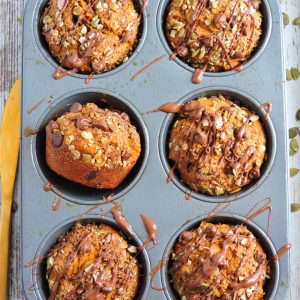 Chocolate Pumpkin Streusel Muffins in a tin muffin pan with a chocolate drizzle. beautifuleatsandthings.com