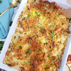 The best 3-cheese green bean casserole made with Campbell’s® Cream of Mushroom Soup, Del Monte® Green Beans and French’s® Original Crispy Fried Onions, in a white casserole dish