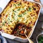 shepherd's pie in a white casserole dish topped with fresh chopped parsley beautifuleatsandthings.com