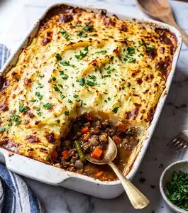 shepherd's pie in a white casserole dish topped with fresh chopped parsley beautifuleatsandthings.com