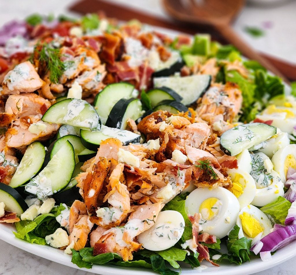 Salmon Cobb Salad topped with a creamy dill dressing served on a white platter
beautifuleatsandthings.com