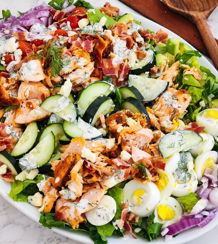 Salmon Cobb Salad topped with a creamy dill dressing served on a white platter
beautifuleatsandthings.com