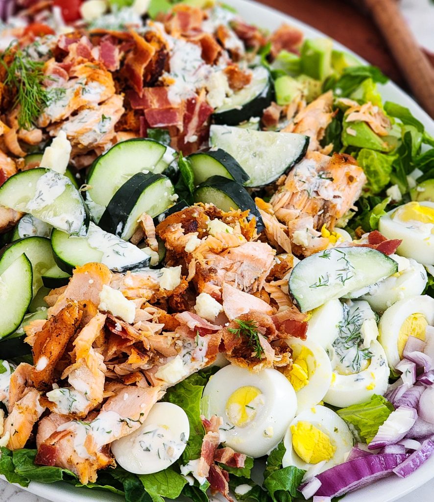 Salmon Cobb Salad topped with a creamy dill dressing served on a white platter
beautifuleatsandthings.com