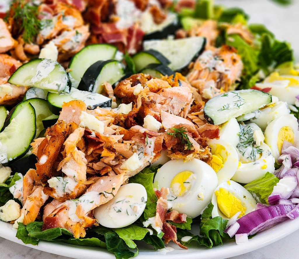 Salmon Cobb Salad topped with a creamy dill dressing served on a white platter
beautifuleatsandthings.com