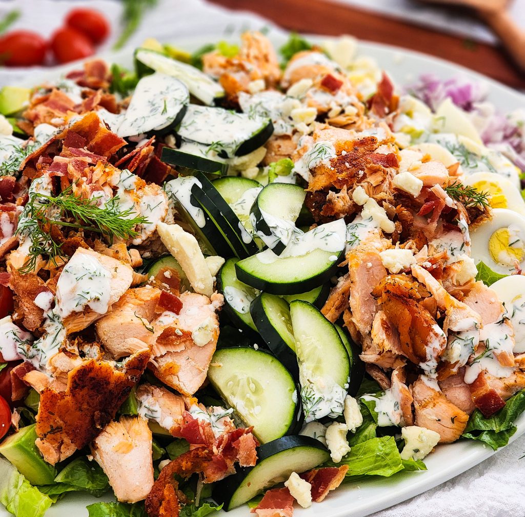 Salmon Cobb Salad topped with a creamy dill dressing served on a white platter
beautifuleatsandthings.com