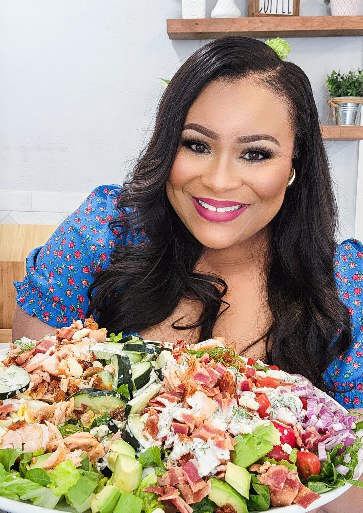 Black Registered Dietitian holding a Salmon Cobb Salad topped with a creamy dill dressing served on a white platter
beautifuleatsandthings.com