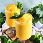 Passionfruit Mango Pineapple Frosé in a cocktail glass topped with fresh mint beautifuleatsandthings.com