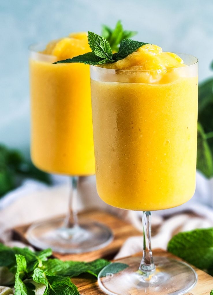 Passionfruit Mango Pineapple Frosé in a cocktail glass topped with fresh mint
beautifuleatsandthings.com