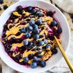 Loaded Blueberry Oatmeal topped with Peanut Butter in a white bowl, healthy breakfast