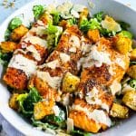 easy salmon Caesar salad, seared and plated in a white bowl topped with homemade caesar dressing and homemade croutons beautifuleatsandthings.com