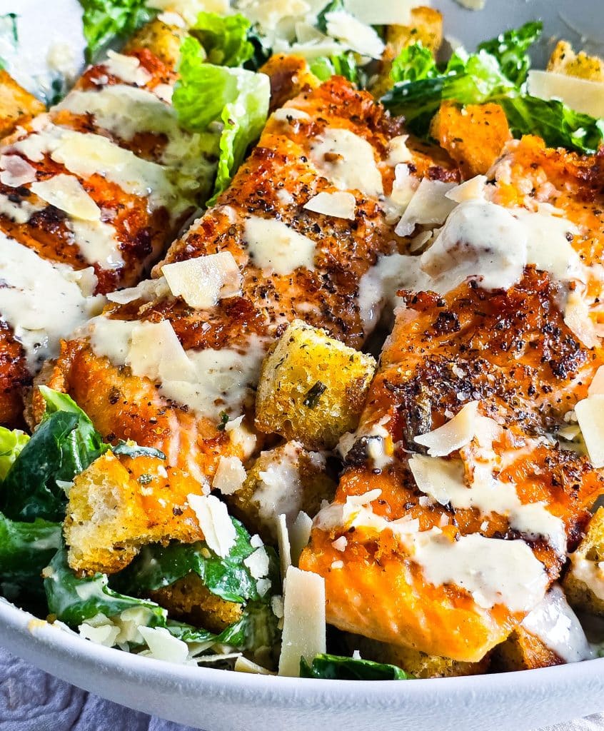 easy salmon Caesar salad, seared and plated in a white bowl topped with homemade caesar dressing and homemade croutons
beautifuleatsandthings.com