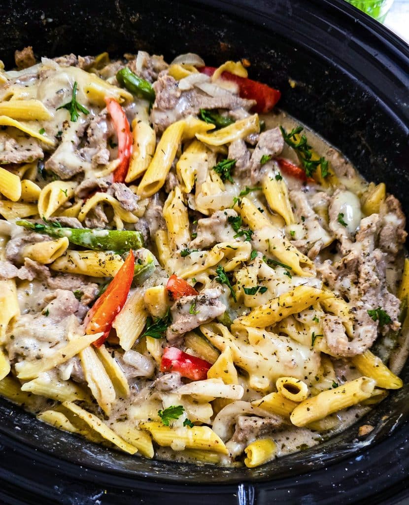 Easy Crockpot Philly Cheesesteak Pasta made in a black slow cooker with red and green bell peppers
beautifuleatsandthings.com