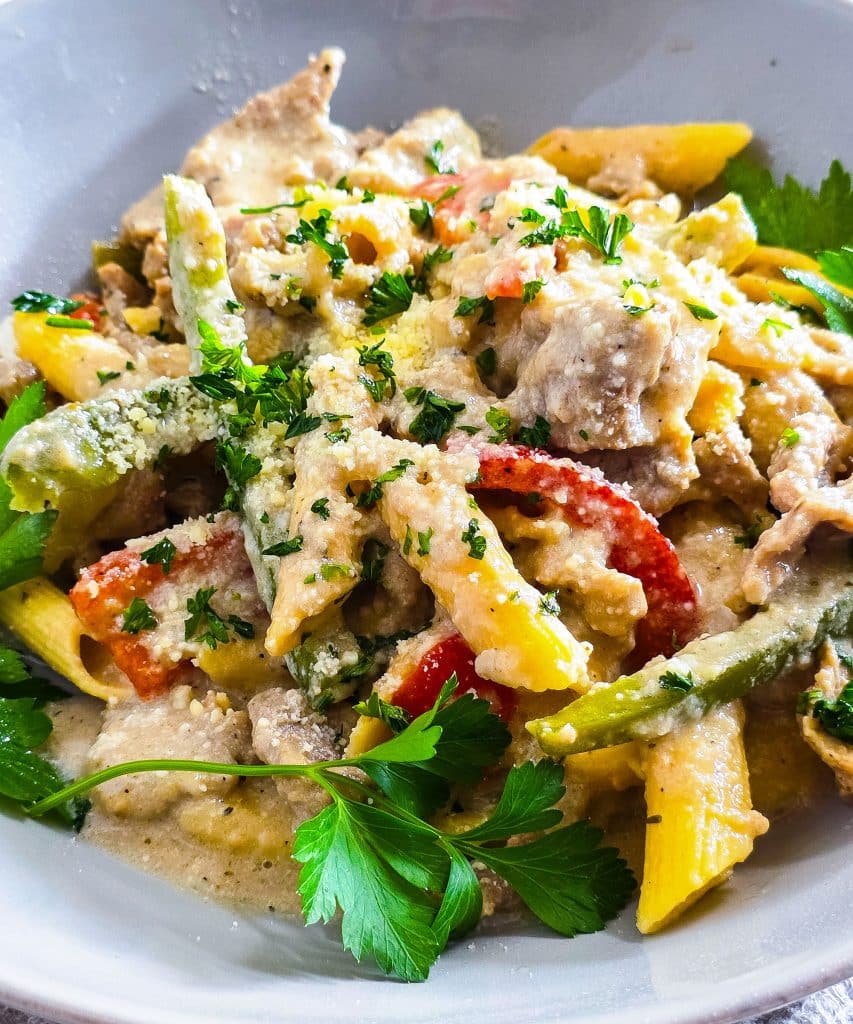 Easy Crockpot Philly Cheesesteak Pasta made in a black slow cooker with red and green bell peppers
beautifuleatsandthings.com
