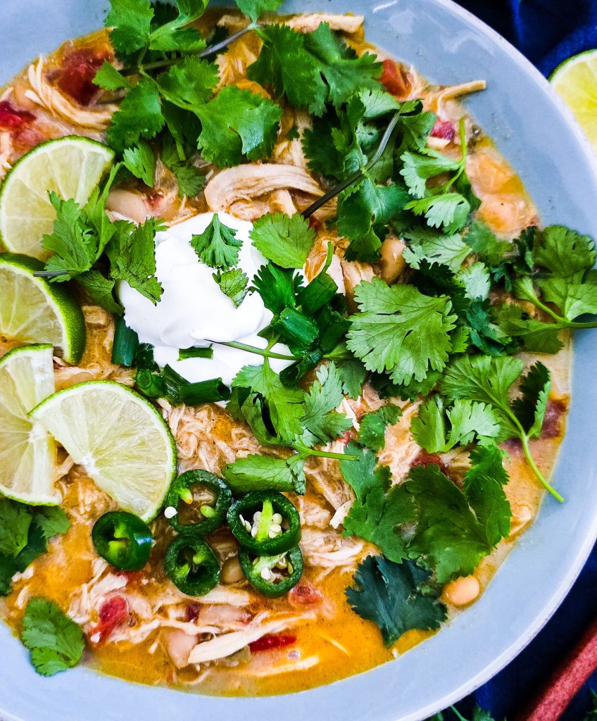 Slow Cooker Creamy White Chicken Chili (Crockpot Recipe) for busy weeknights, easy recipes for busy families, topped with cilantro, limes, sour cream and green onions beautifuleatsandthings.com