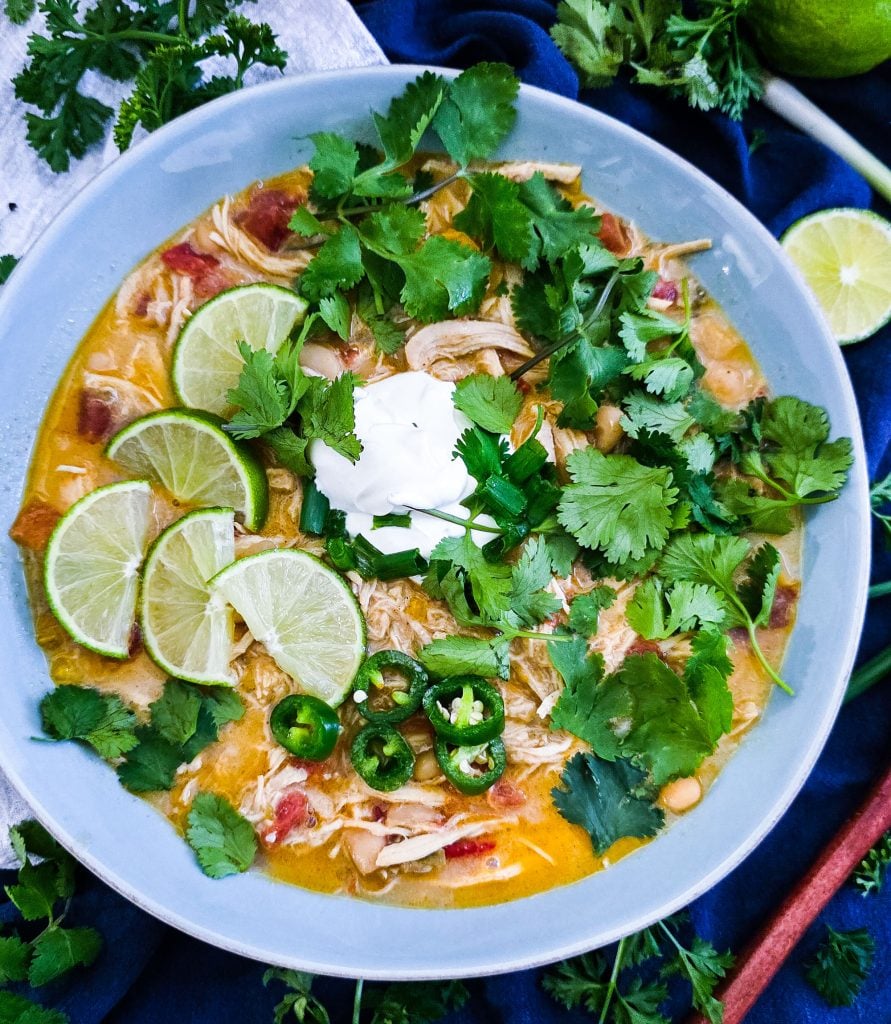 Slow Cooker Creamy White Chicken Chili (Crockpot Recipe) for busy weeknights, easy recipes for busy families, topped with cilantro, limes, sour cream and green onions beautifuleatsandthings.com
