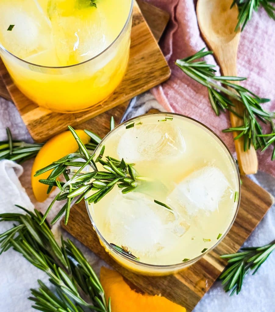 ginger peach sparkling mocktail in a short cocktail glass, garnished with rosemary beautifuleatsandthings.com