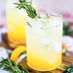 ginger peach sparkling mocktail in a short cocktail glass, garnished with rosemary beautifuleatsandthings.com