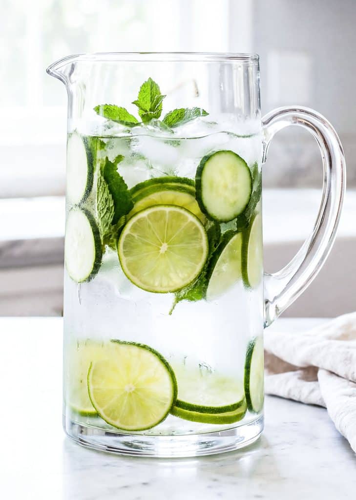 Cucumber lime mint infused water in a glass pitcher for hydration
beautifuleatsandthings.com