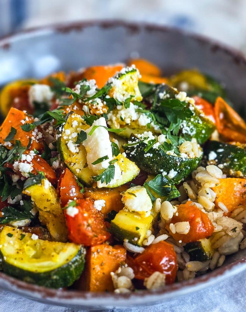 healthy high fiber grain bowl with zucchini, sweet potatoes, and tomatoes served over cooked barley in a gray bowl
beautifuleatsandthings.com