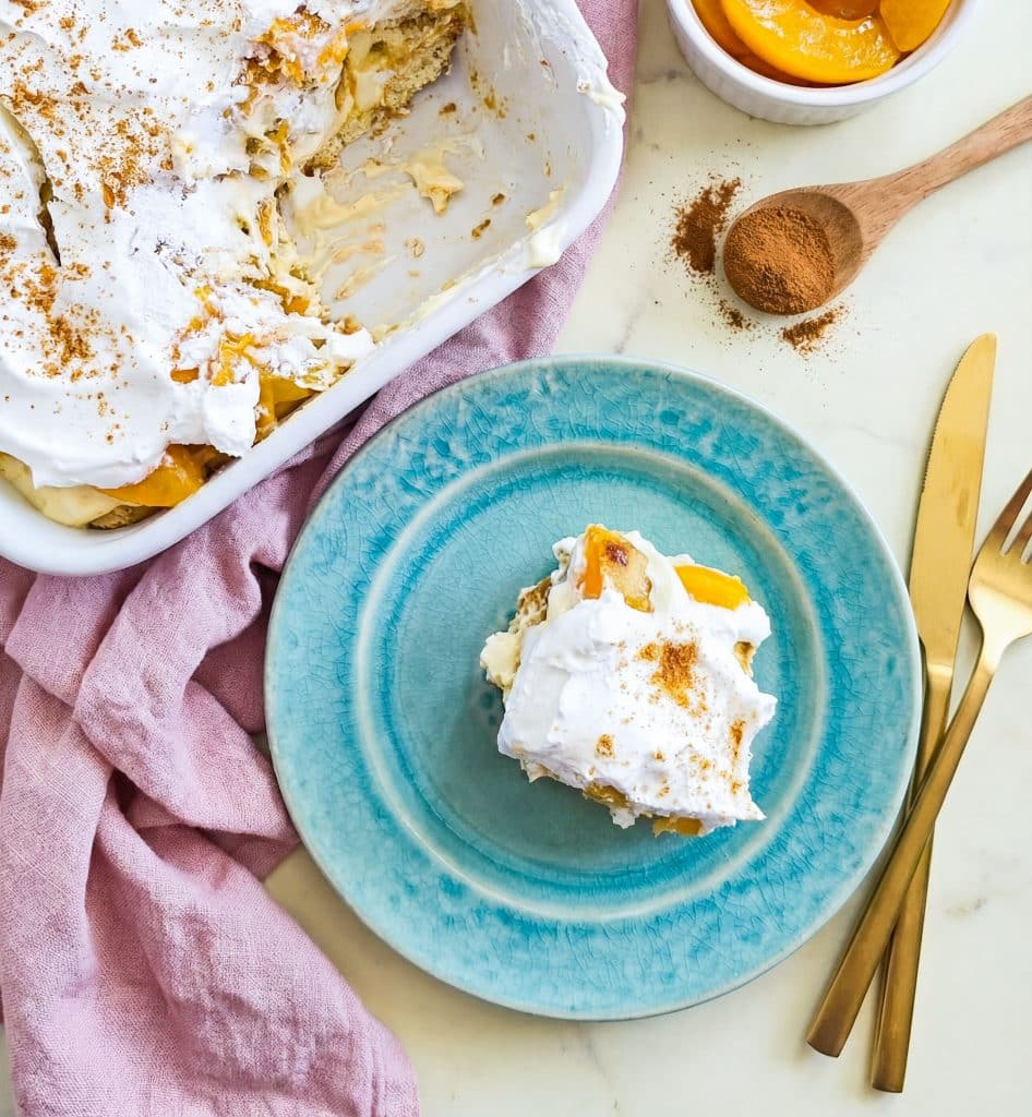 Easy no-bake peach pudding made with canned peaches, whipped topping, and vanilla wafers layered in a glass dish, served on a blue plate beautifuleatsandthings.com