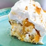 Easy no-bake peach pudding made with canned peaches, whipped topping, and vanilla wafers layered in a glass dish, served on a blue plate beautifuleatsandthings.com