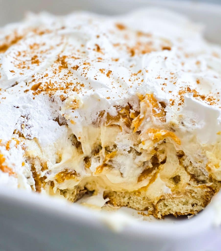 Easy no-bake peach pudding made with canned peaches, whipped topping, and vanilla wafers layered in a glass dish, served on a blue plate beautifuleatsandthings.com