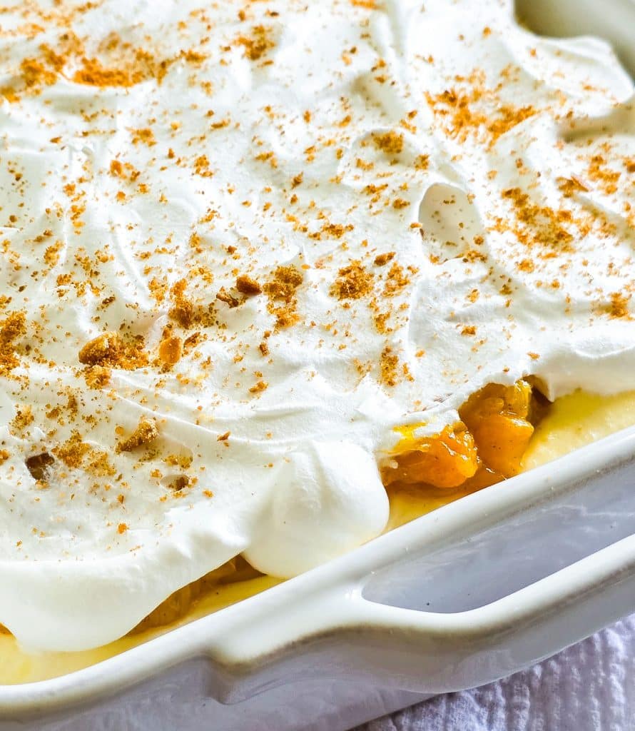 Easy no-bake peach pudding made with canned peaches, whipped topping, and vanilla wafers layered in a glass dish, served on a blue plate beautifuleatsandthings.com
