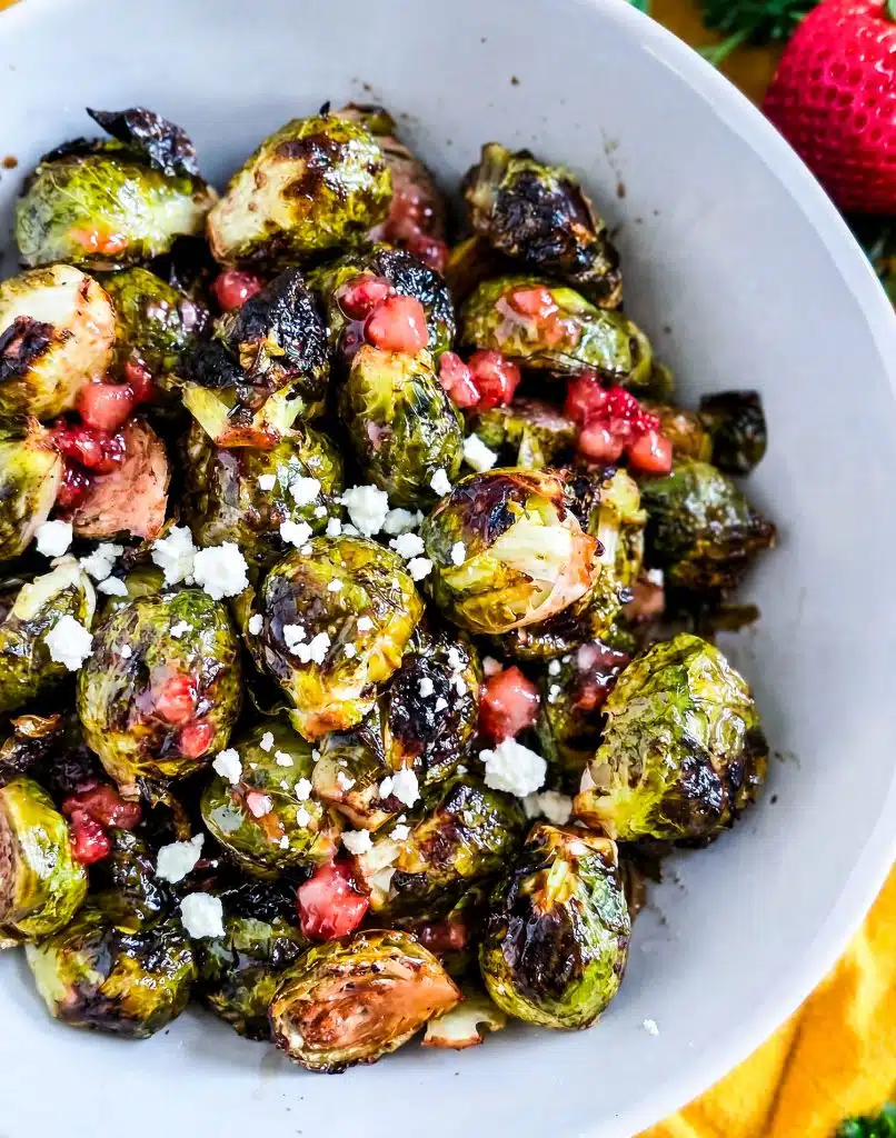 Crispy Oven Roasted Brussels Sprouts with Strawberry Lemonade Flavor, in a white bowl with crumbled feta cheese
beautifuleatsandthings.com