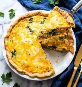 Golden baked salmon and spinach quiche made with sockeye salmon, spinach, cheddar, and Parmesan cheese in a flaky pie crust. beautifuleatsandthings.com