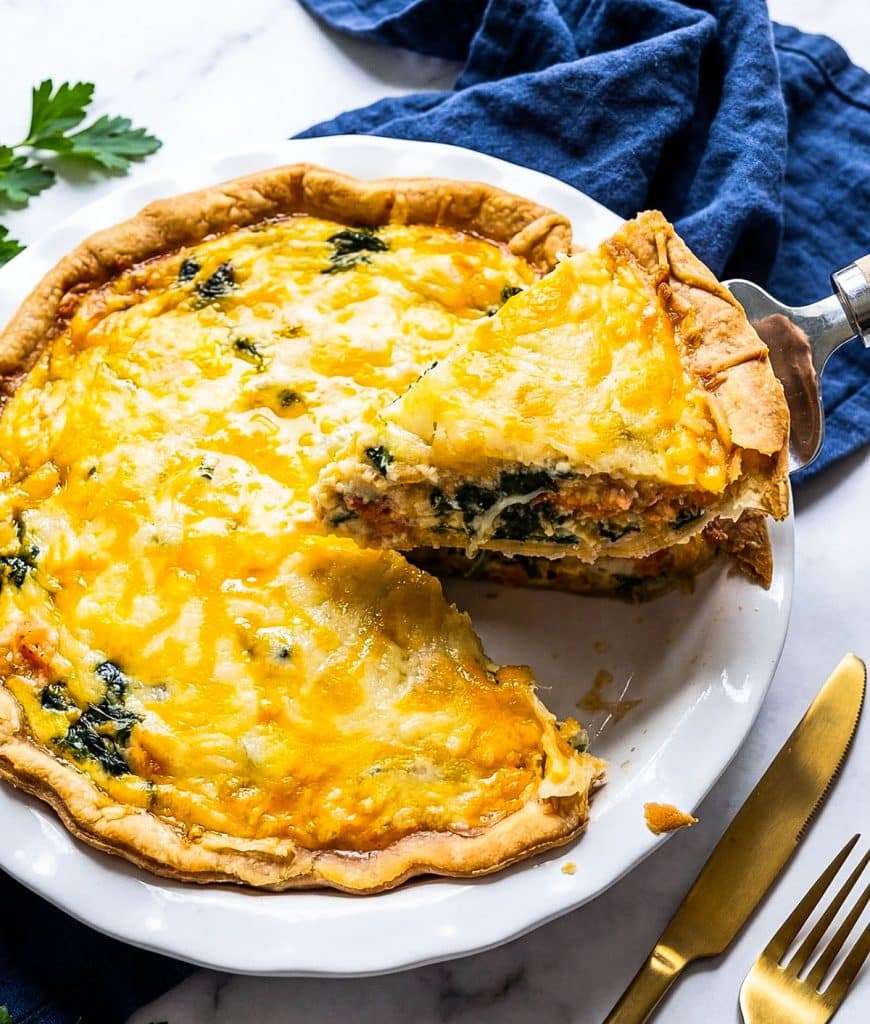 Golden baked salmon and spinach quiche made with sockeye salmon, spinach, cheddar, and Parmesan cheese in a flaky pie crust. beautifuleatsandthings.com