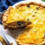 Golden baked salmon and spinach quiche made with sockeye salmon, spinach, cheddar, and Parmesan cheese in a flaky pie crust.