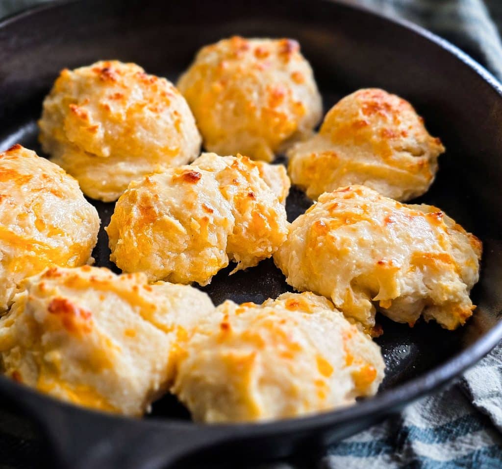 Easy homemade drop cheese biscuits baked in a cast iron skillet until golden brown, topped with melted butter beautifuleatsandthings.com