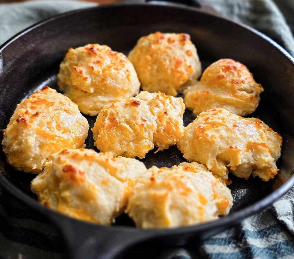 Easy homemade drop cheese biscuits baked in a cast iron skillet until golden brown, topped with melted butter beautifuleatsandthings.com