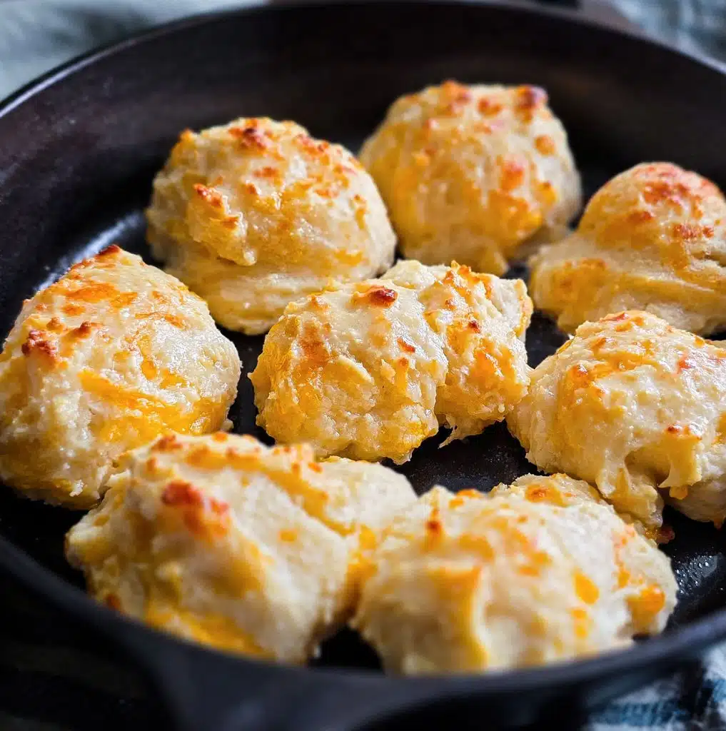 Easy homemade drop cheese biscuits baked in a cast iron skillet until golden brown, topped with melted butter
beautifuleatsandthings.com