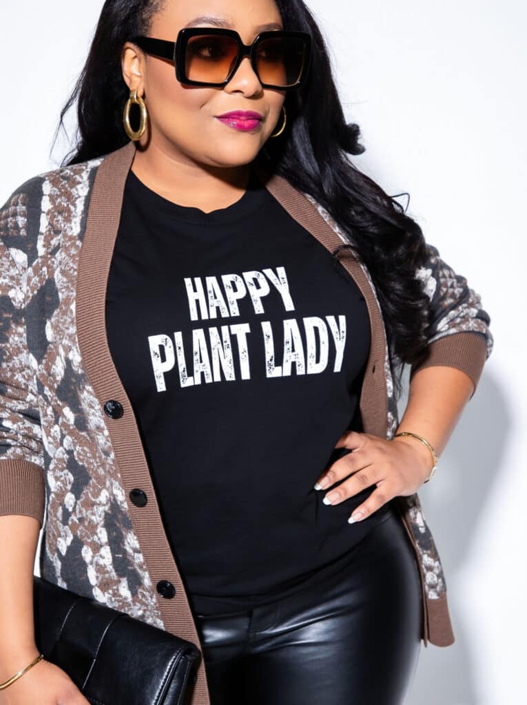 Plus size brown cardigan outfit with black graphic tee and faux leather pants